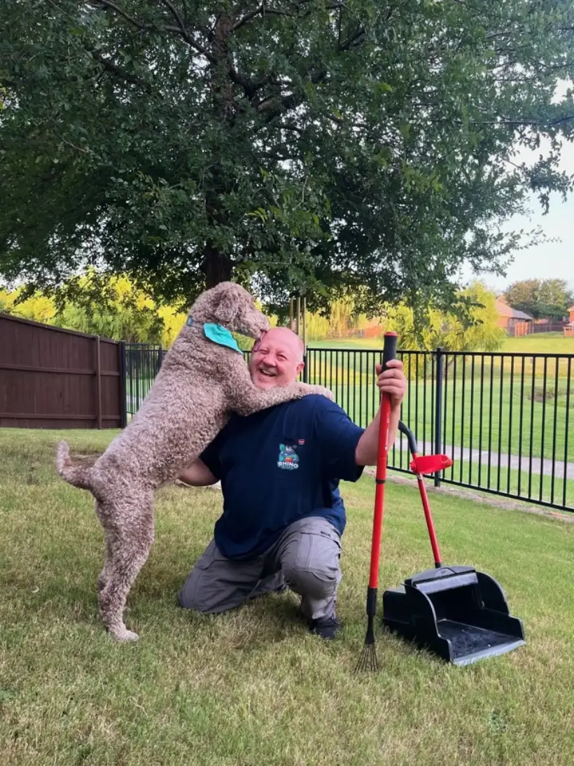 A happy customer dog jumping up on Paul in a clean Fort Worth yard
