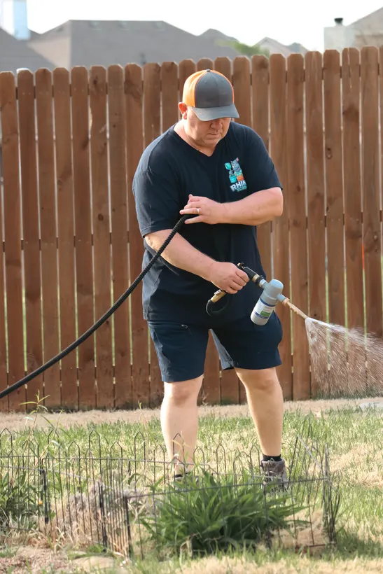 Spraying a yard treatment after a Rhino Scoop cleanup
