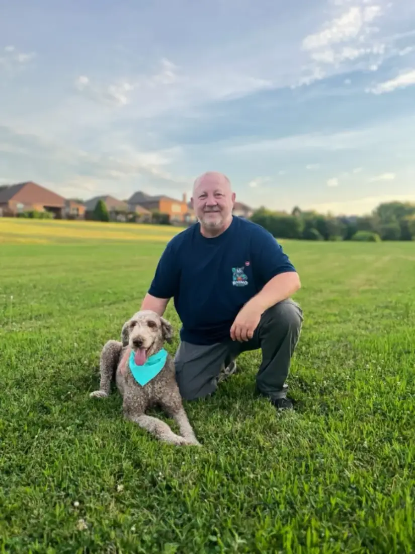 Paul on a large open lawn with a dog, the kind of common area Rhino Scoop services